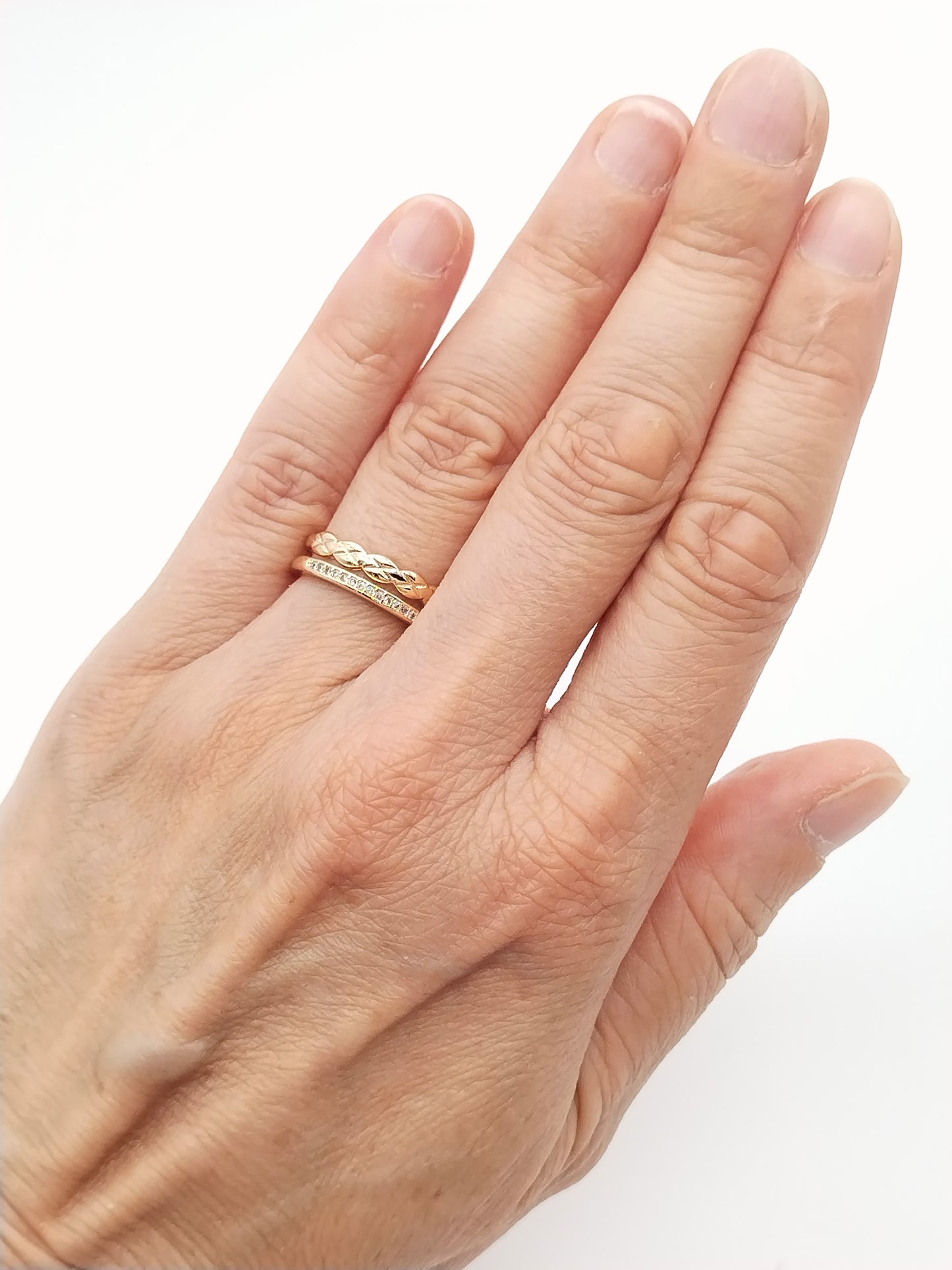 Side view of double band braided ring in 18k gold plated finish with cubic zirconia accent