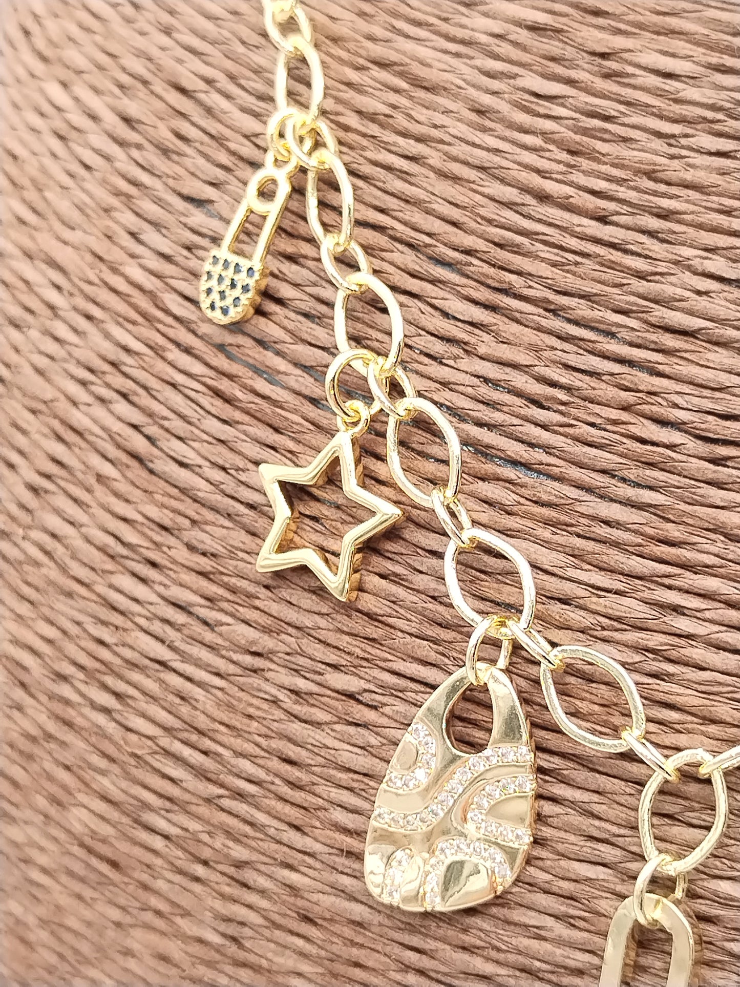 Gold charm necklace showing lobster clasp and extender chain detail