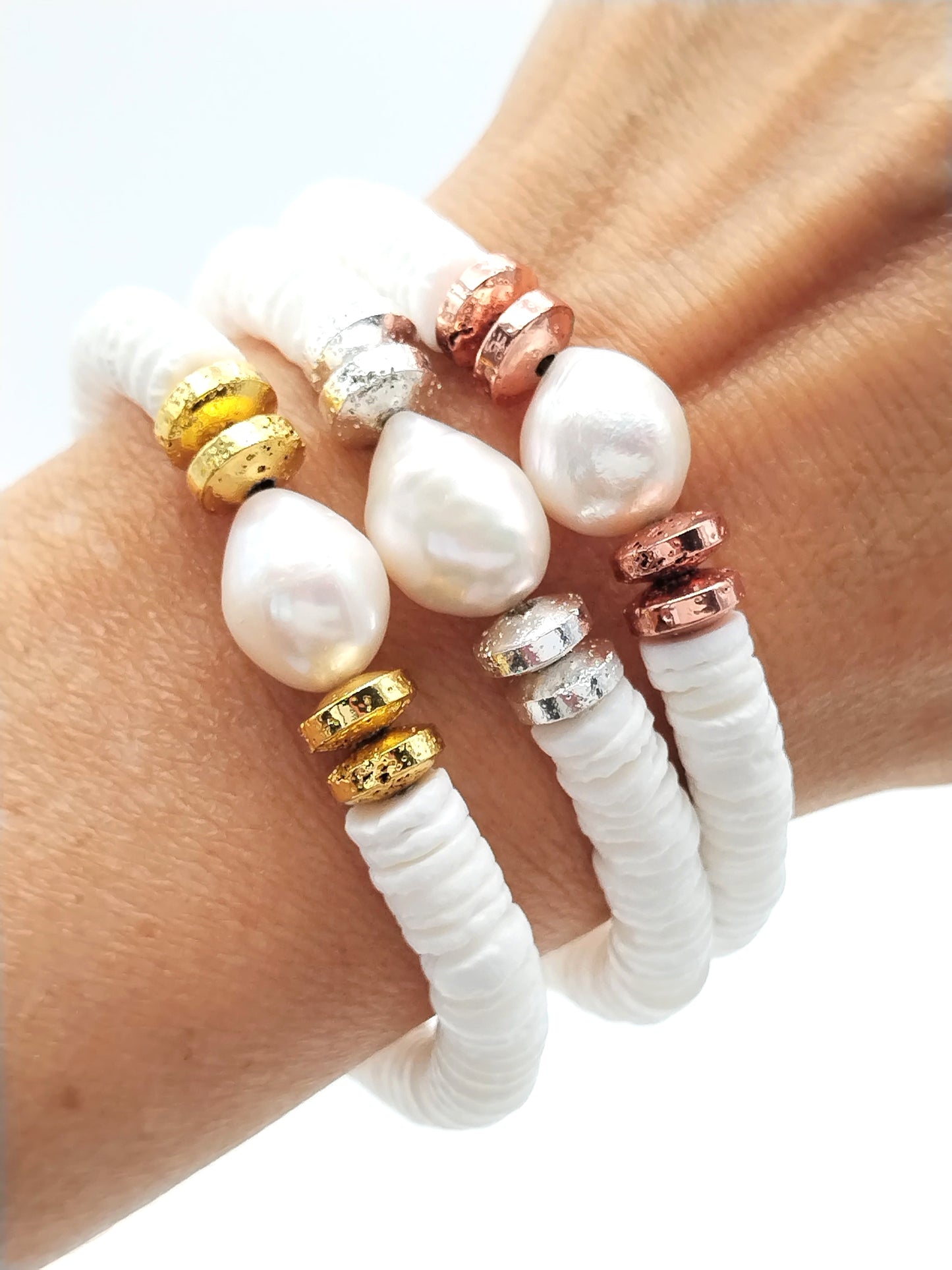Pulseras de oro, plata y cobre con conchas blancas y perlas barrocas