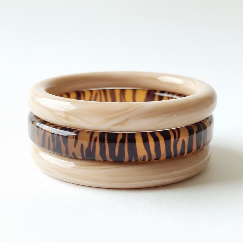 Three stacked resin bangles in beige marble and animal print