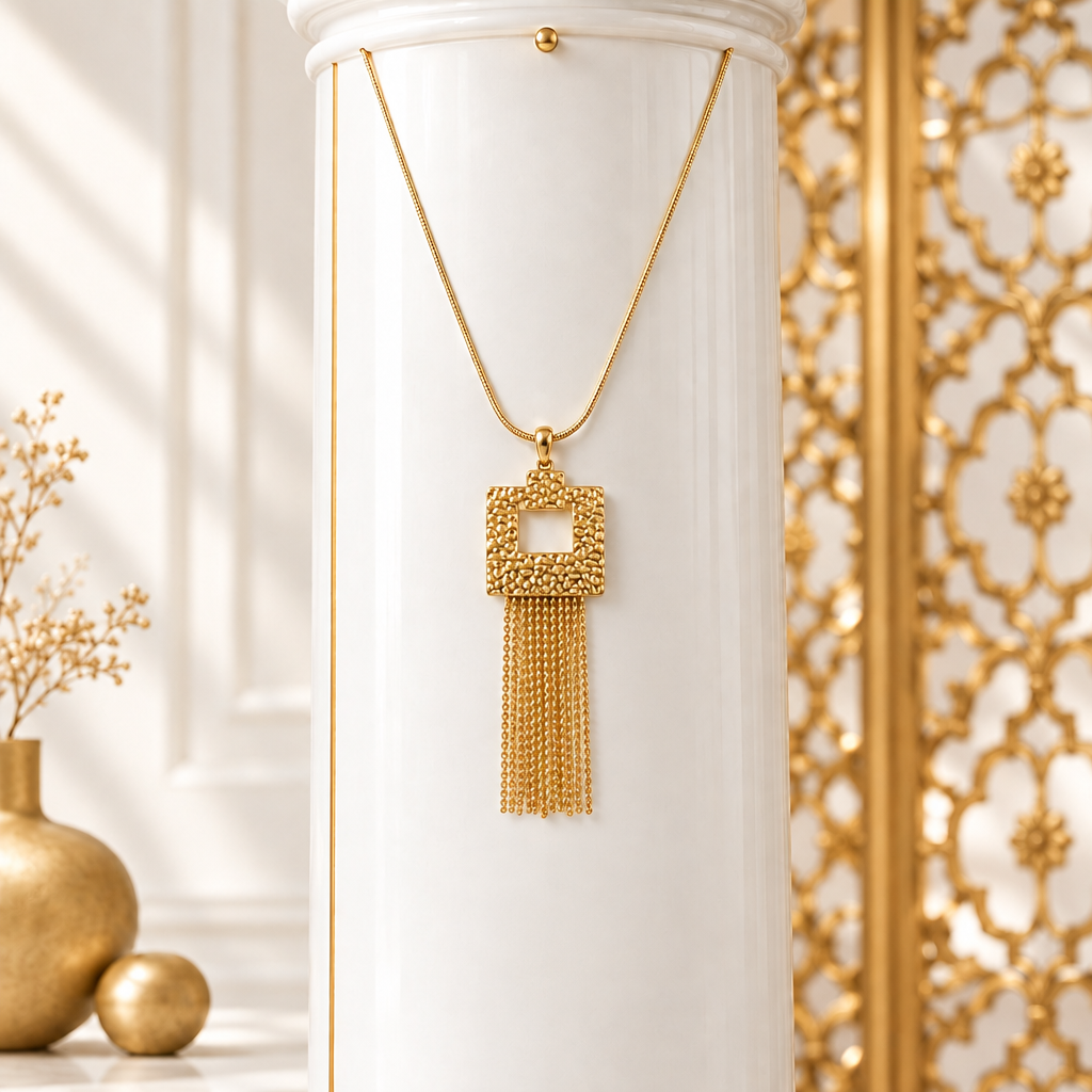 Square fringe pendant necklace hanging on a white column beside an ornate gold grille