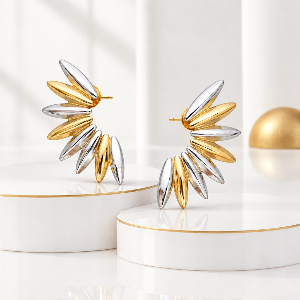 Sculptural petal earrings in 18k PVD Gold and rhodium on white podiums with fine gold edges and matte gold decor