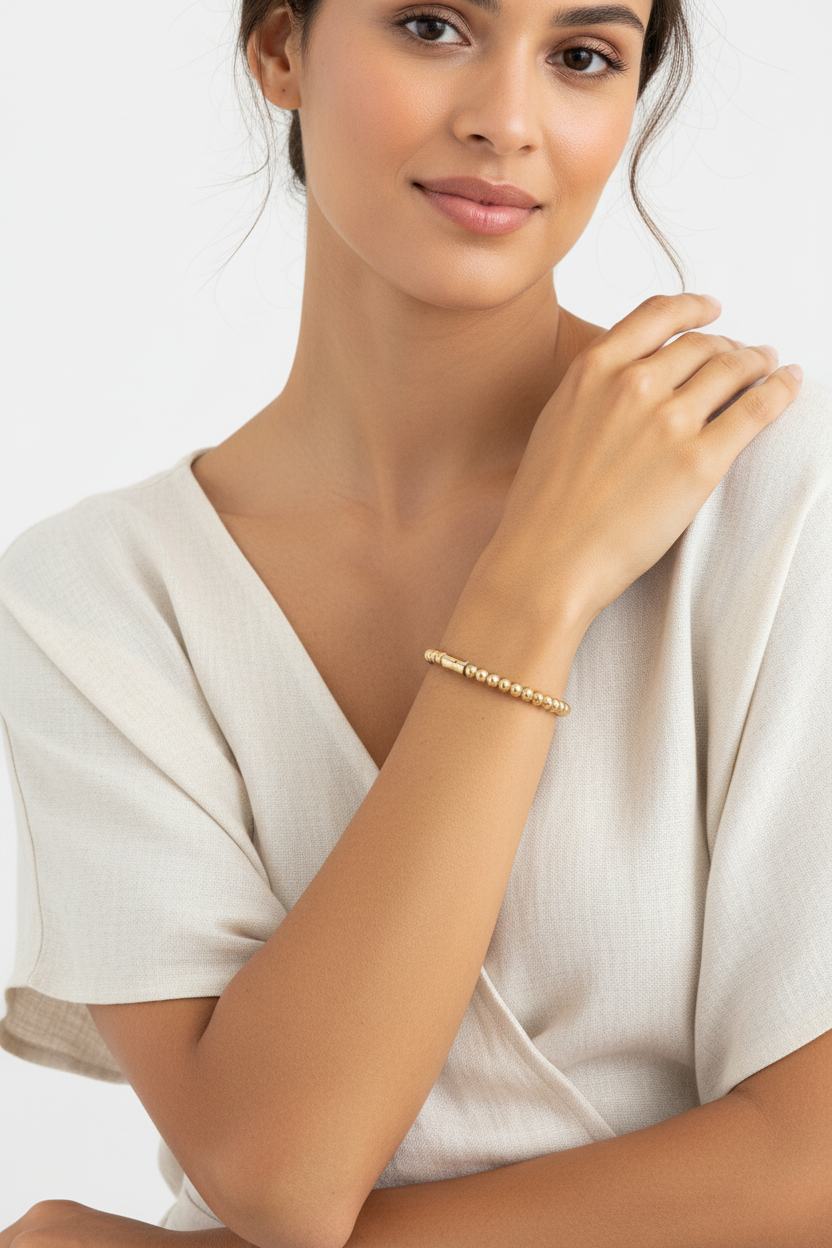 Gold plated statement bangle bracelet on wrist - women's luxury jewelry everyday wear