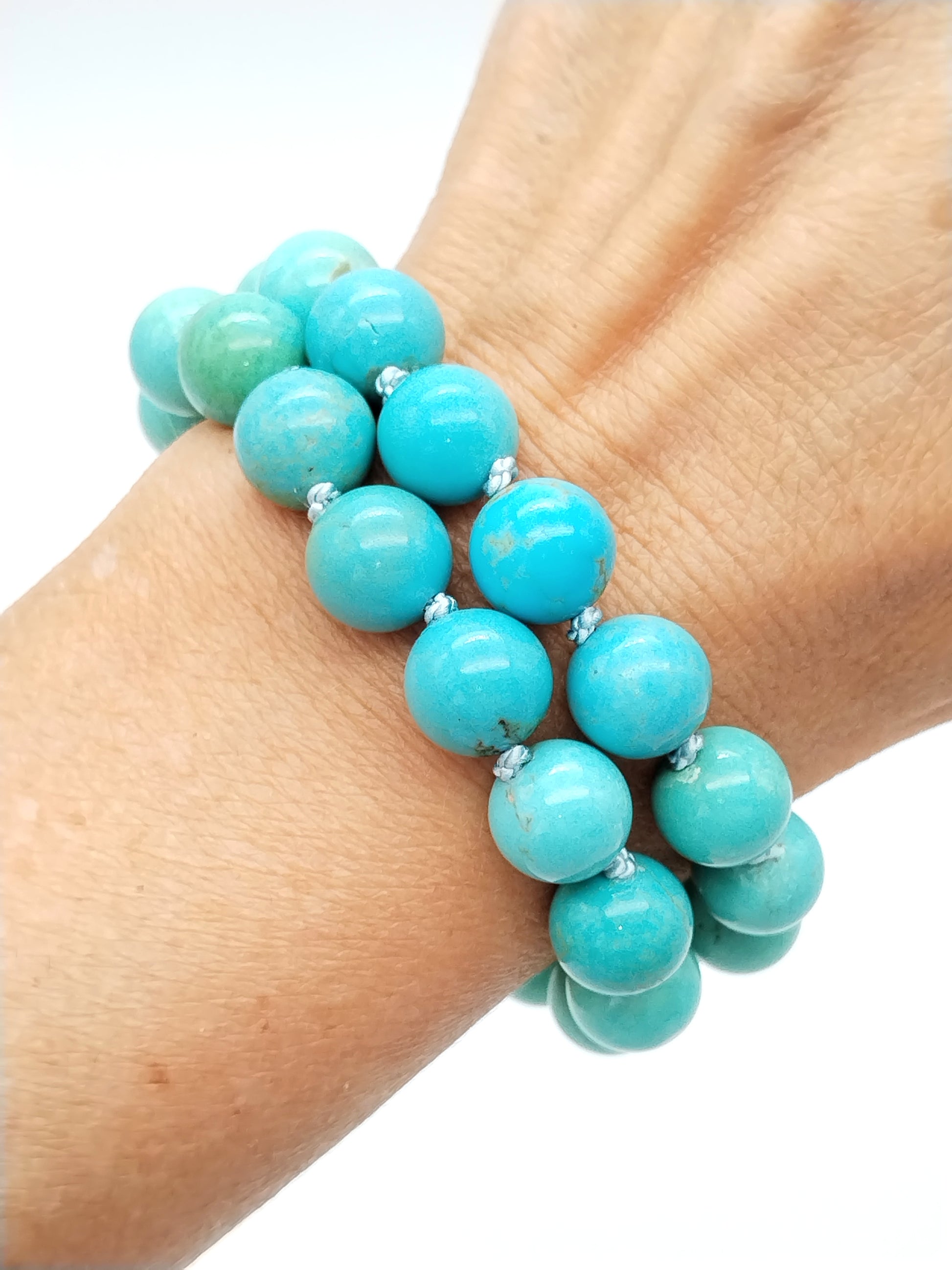 Detail shot of 14k white gold decorative knot clasp on turquoise bracelet