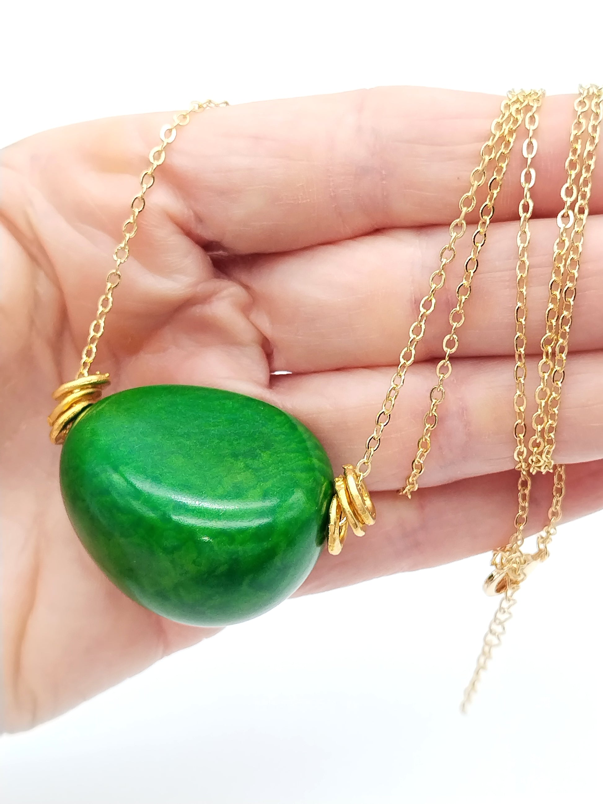 Close-up of colorful nugget tagua beads on gold chain necklace