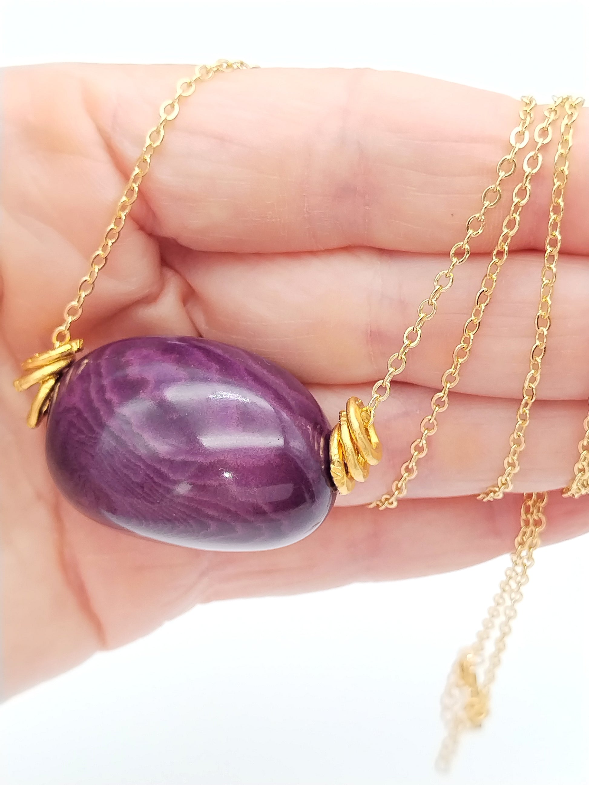 Close-up of purple-plum tagua beads showing natural texture and color variation