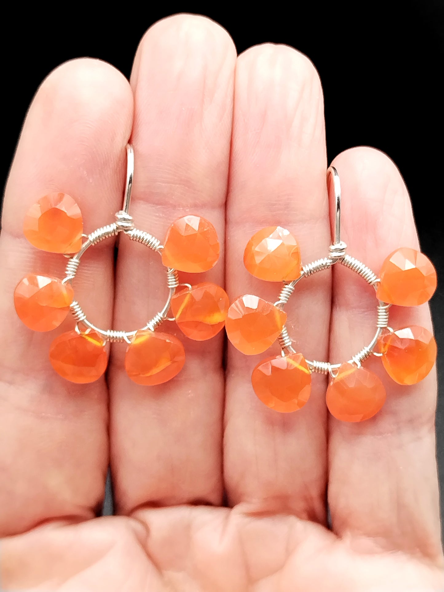 Close-up of carnelian gemstone on open hoop with sterling silver hook earring