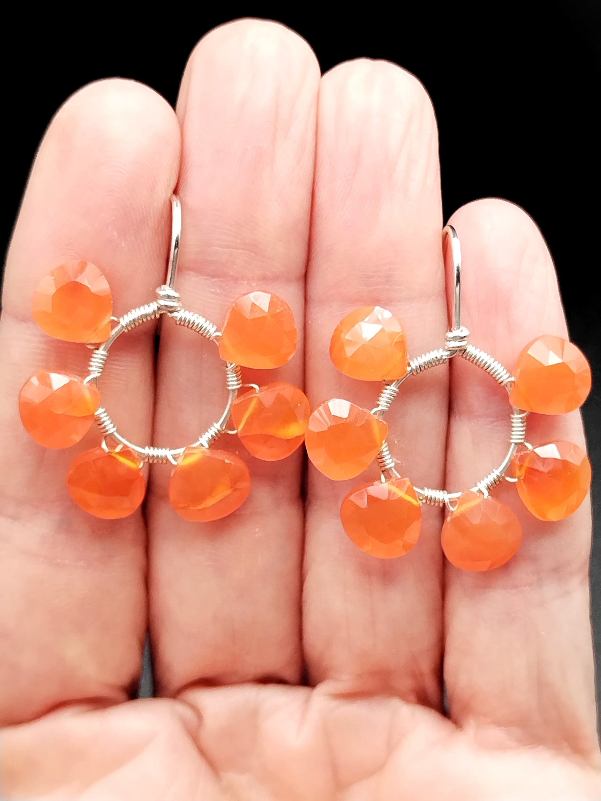 Close-up of carnelian gemstone on open hoop with sterling silver hook earring
