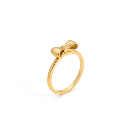 Gold bow ring with a slim polished band shown at a three quarter angle on a white background
