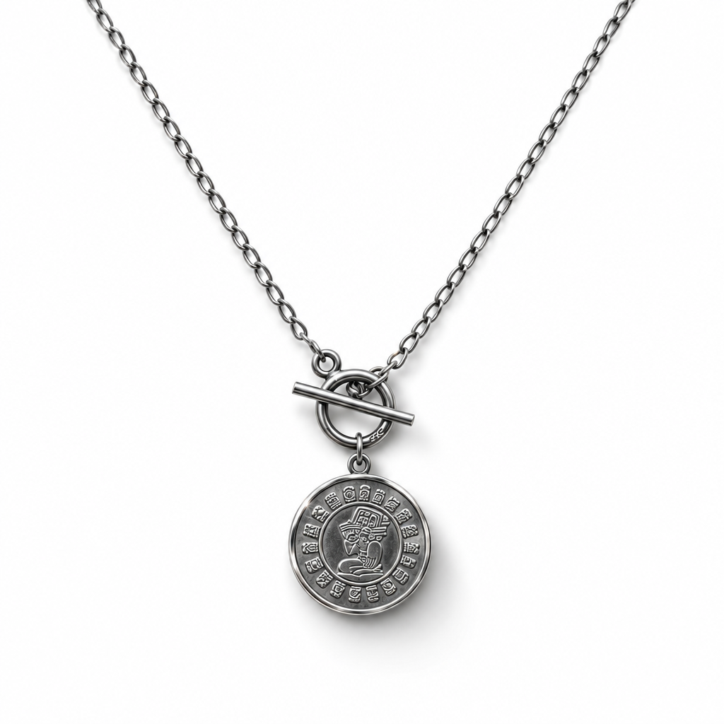 Reverse side of a sterling silver coin necklace with an engraved profile and surrounding symbols