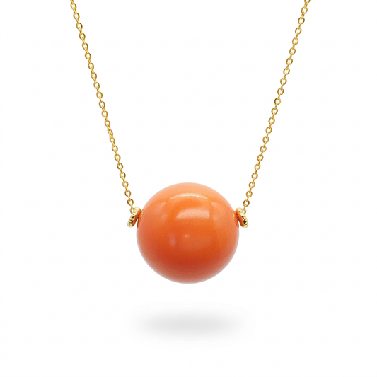 Orange tagua bead necklace with an 18k gold plated chain on a white background