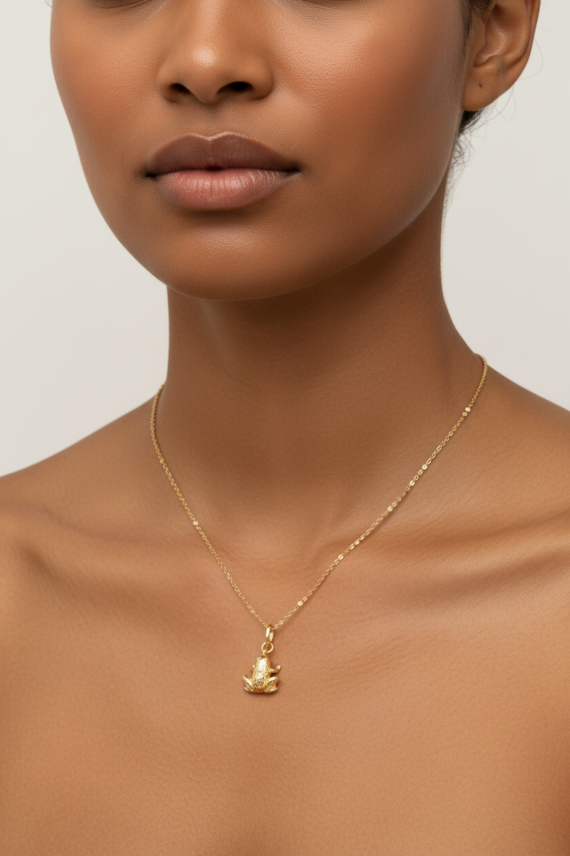 Brown Asian model wearing 18K gold frog charm necklace - dainty layering necklace on skin
