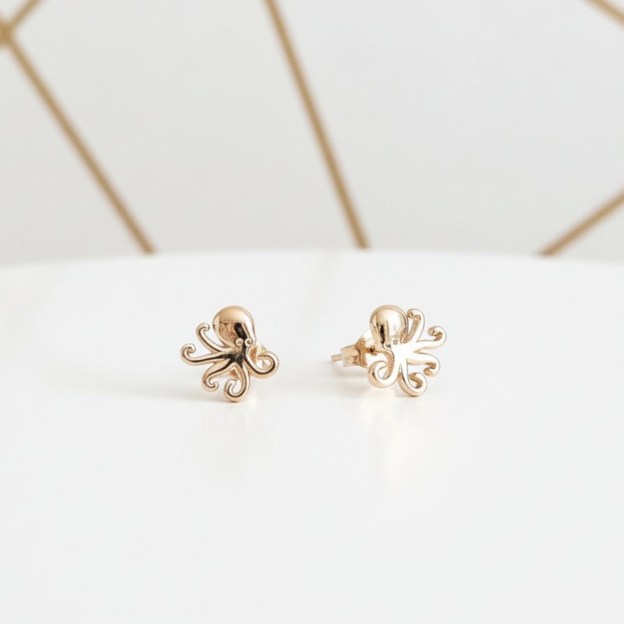 Gold plated octopus earrings 8x9mm displayed in elegant white and gold setting