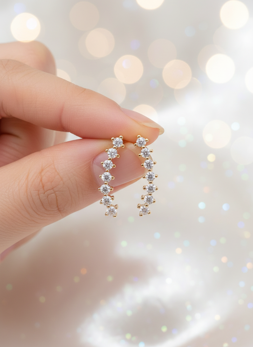 Helix earrings held in hand with pearly white sparkle background