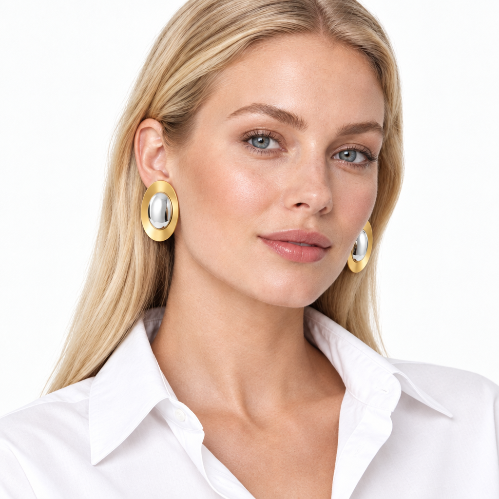 Model wearing oversized 40mm two tone oval stud earrings with a white open collar shirt