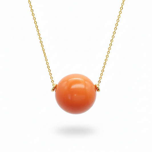 Orange tagua bead pendant necklace with 18k gold plated chain on white background