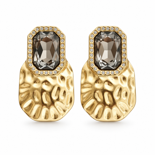 Smoky crystal drop earrings in 18k PVD Gold with pavé frames and hammered plates on a white background