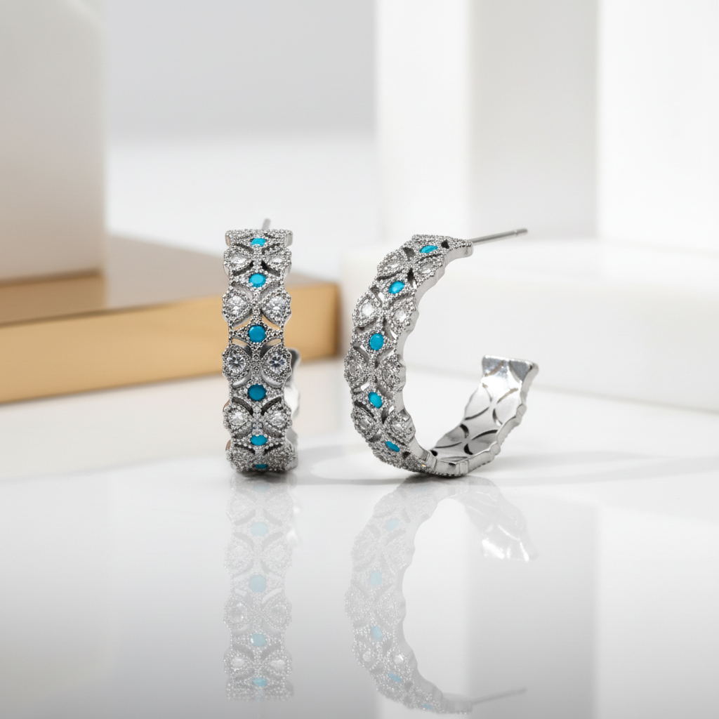Close-up detail of rhodium plated open hoops featuring white and turquoise cubic zirconia stud earrings