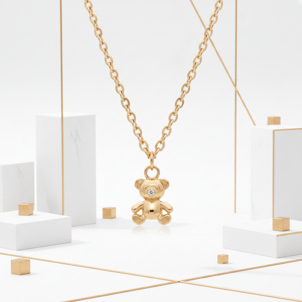 18k gold plated teddy bear CZ charm necklace displayed on white geometric pedestal with gold bar accents
